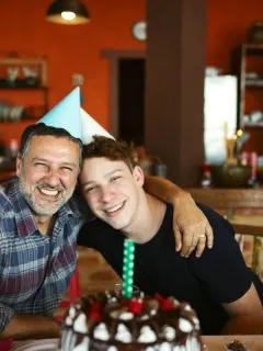 father and son celebrating a birthday with some cake