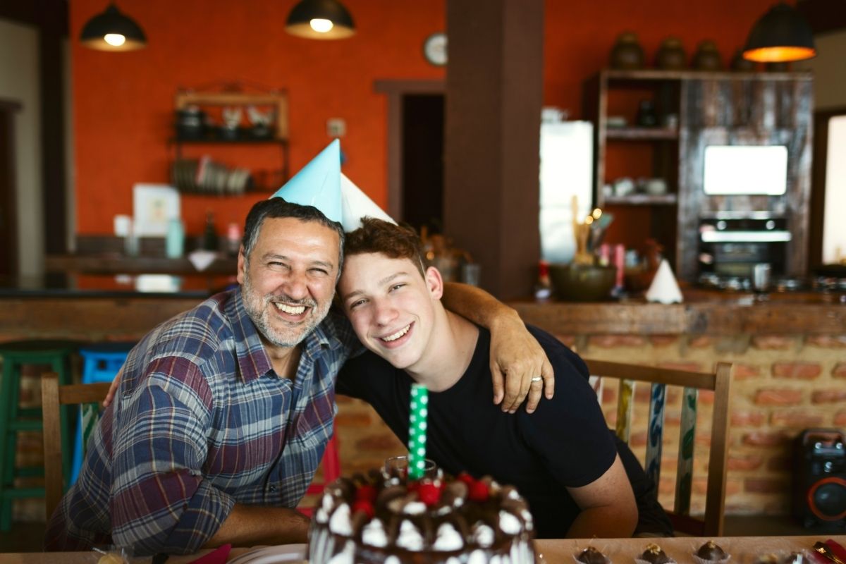 father and son celebrating a birthday with some cake