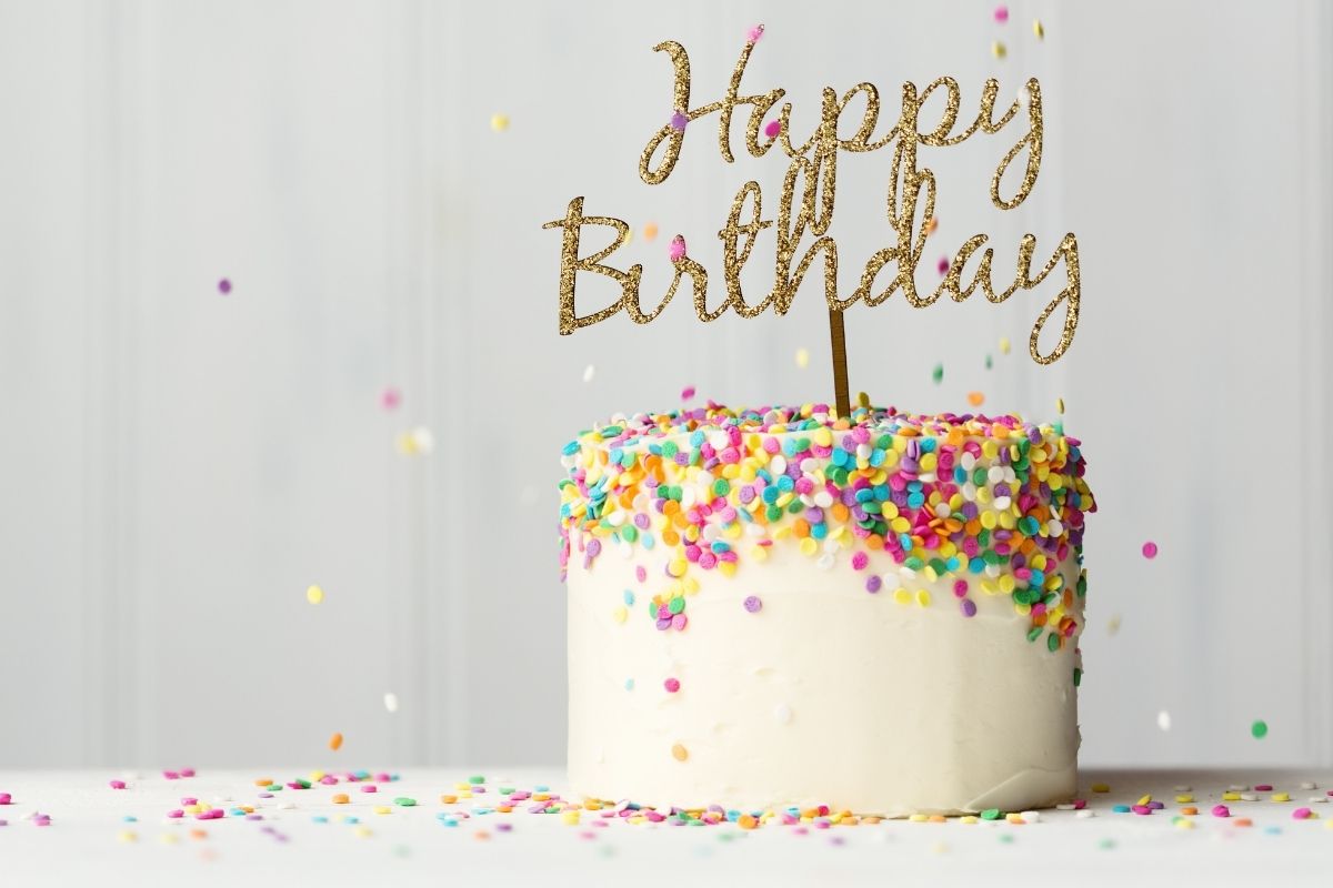 white birthday cake with colorful sprinkles