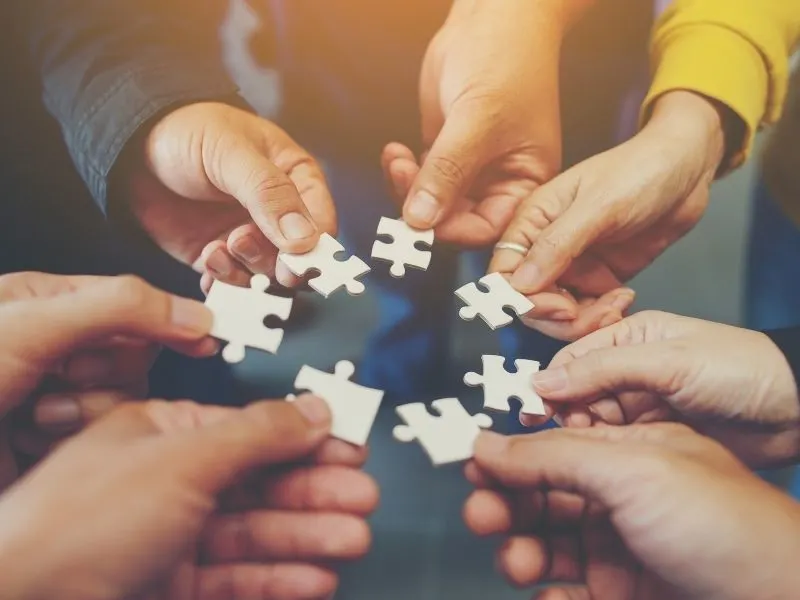 people's hands with puzzle pieces