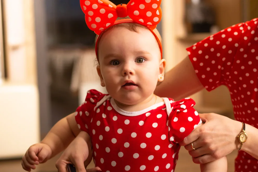 Cute one year old girl dressed up in a polka dot red dress