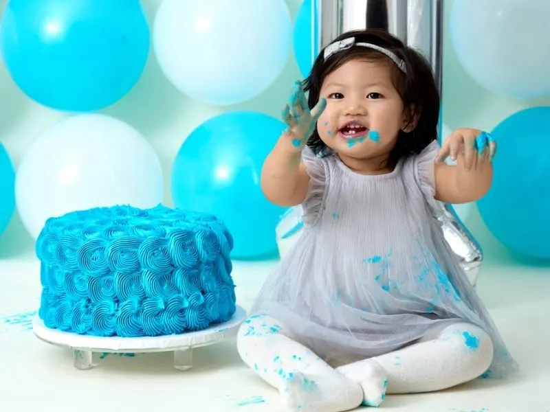 toddler working on a blue cake smash