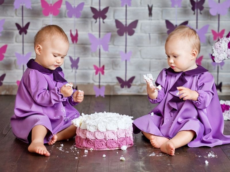 adorable twin girls enjoying their first birthday cake