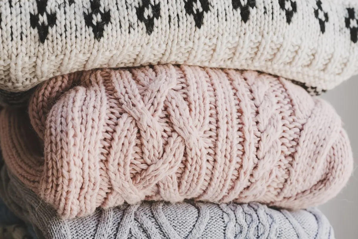 a stack of handmade sweaters