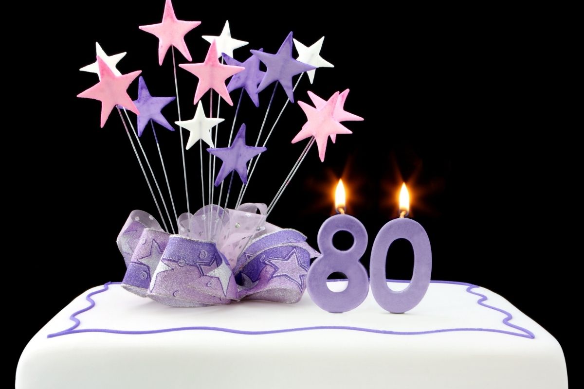 white 80th birthday cake decorated with purple
