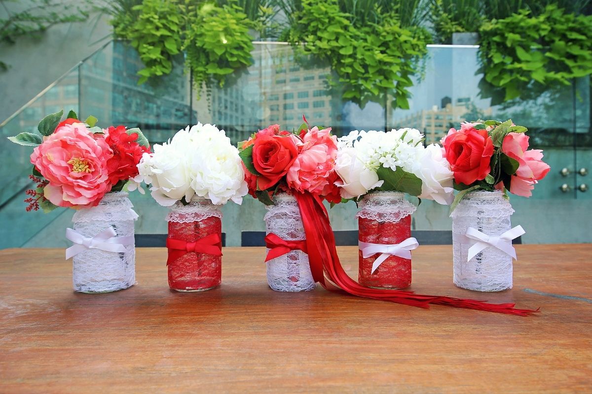 red and white flowers in decorated Mason jars