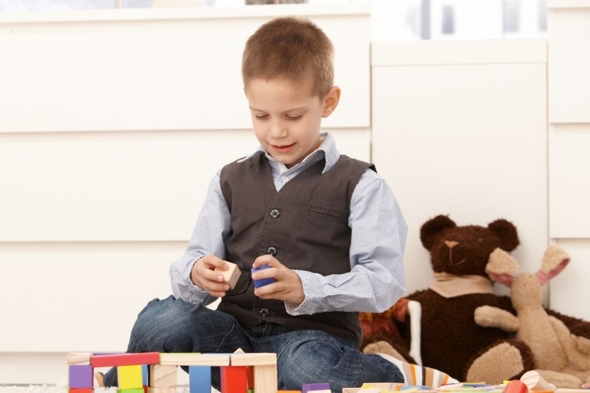 young boy playing with wooden blocks