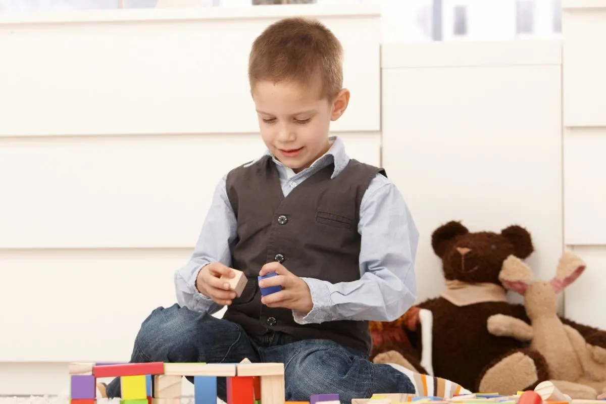 young boy playing with wooden blocks