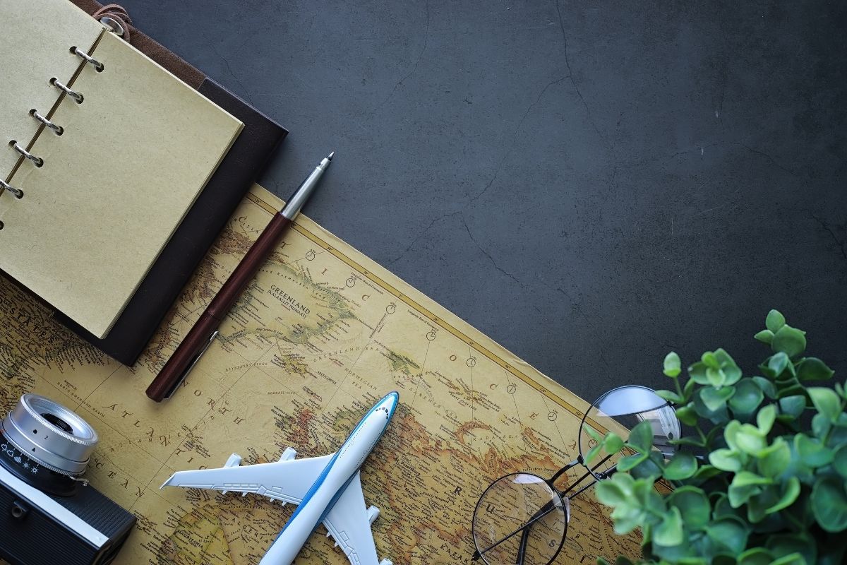 planning a trip: reading glasses, map, toy airplane